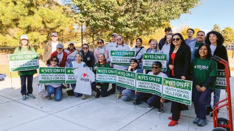 Colorado educators and parents hold signs and rally outdoors for the passage of a ballot measure