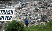 A man stands in front of a river which resembles a mountain of plastic more than a body of water. Caption reads: "Trash River"