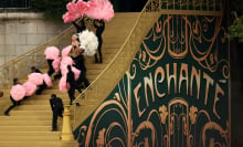 Lady Gaga and dancers stand on golden steps that read "Enchanté".