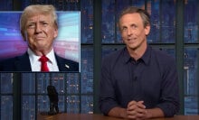 A man in a shirt sits behind a talk show desk. In the top-left is an image of Donald Trump.