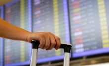 A person wheels luggage through an airport.