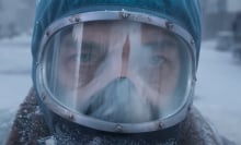 A close-up of a man in a radioactive suit standing outside in the snow.