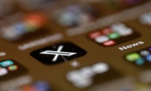 A blurry phone screen, with only the X app logo in focus. 