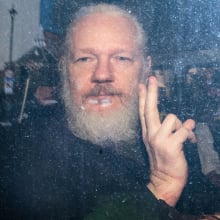 Julian Assange gestures to the media from a police vehicle on April 11, 2019 in London.