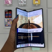 Hand holding Samsung Galaxy Z Fold 6 showcasing main display slightly closed