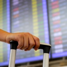 A person wheels luggage through an airport.