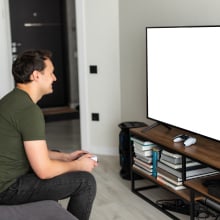 Young happy man laughing and playing video games on weekend