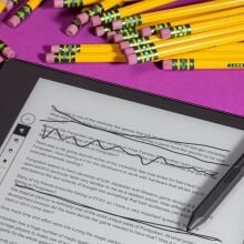 close-up view of kindle scribe with notes on screen and pile of pencils nearby