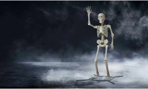 a giant, waving skeleton against a foggy background 