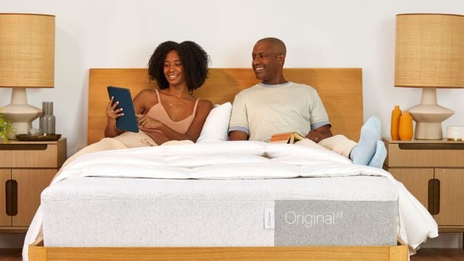 A woman and man sitting on Casper Original Queen Mattress