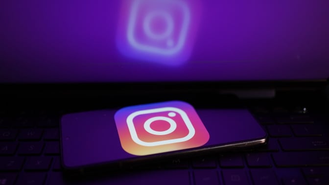 A glowing phone screen shows the Instagram logo. 