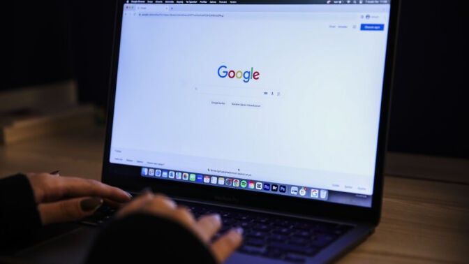 A laptop screen displays the Google search page