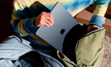 a close-up of a person putting a 15-inch m3 apple macbook air into a backpack