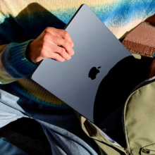 a close-up of a person putting a 15-inch m3 apple macbook air into a backpack