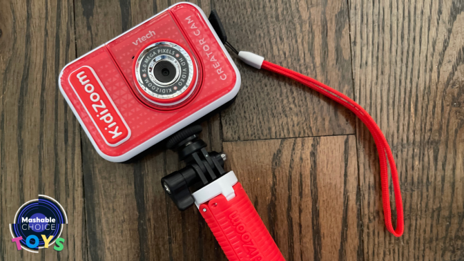 red camera on tripod against wood background