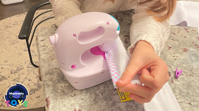 kid sewing on toy sewing machine