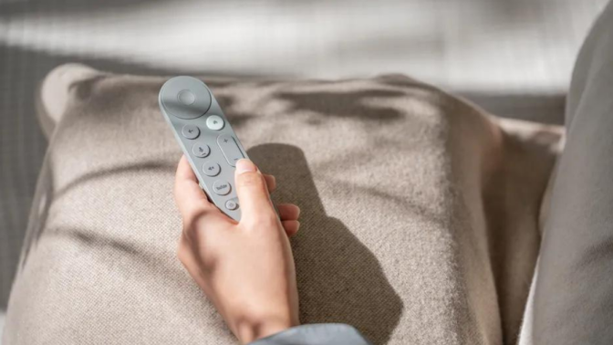 Google TV streamer remote in a person's hand 